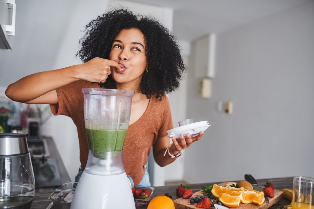 Increasing the body's natural healing power: Young woman getting a taste of her healthy smoothie
